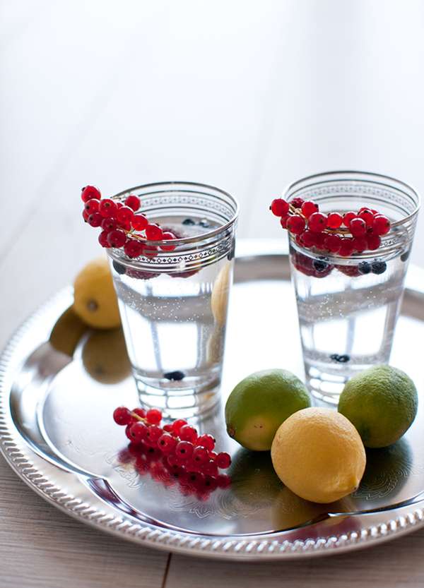 Gelas air jernih dengan hirisan buah di atas meja